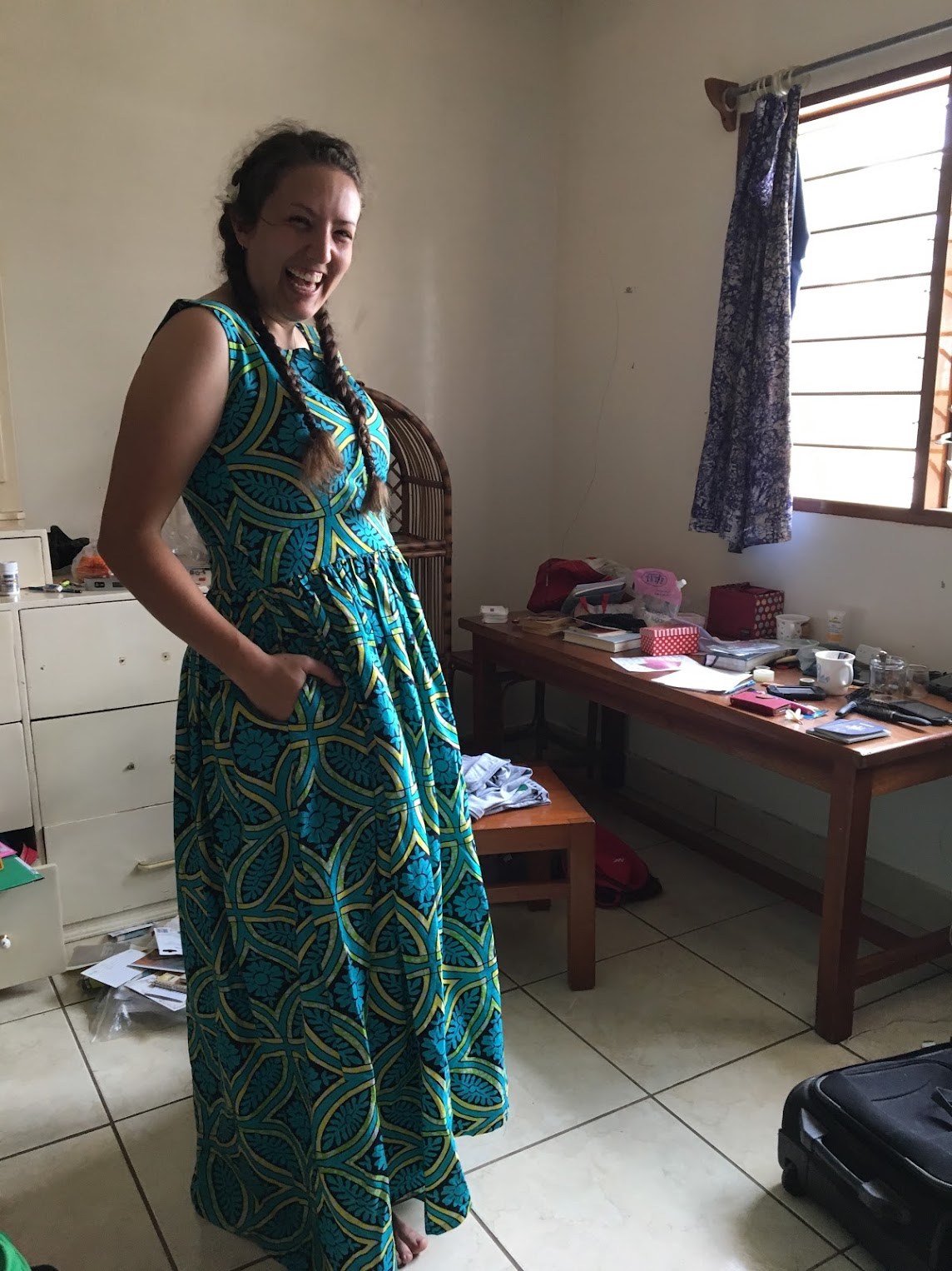 Caity in Africa, wearing a printed dress, laughing