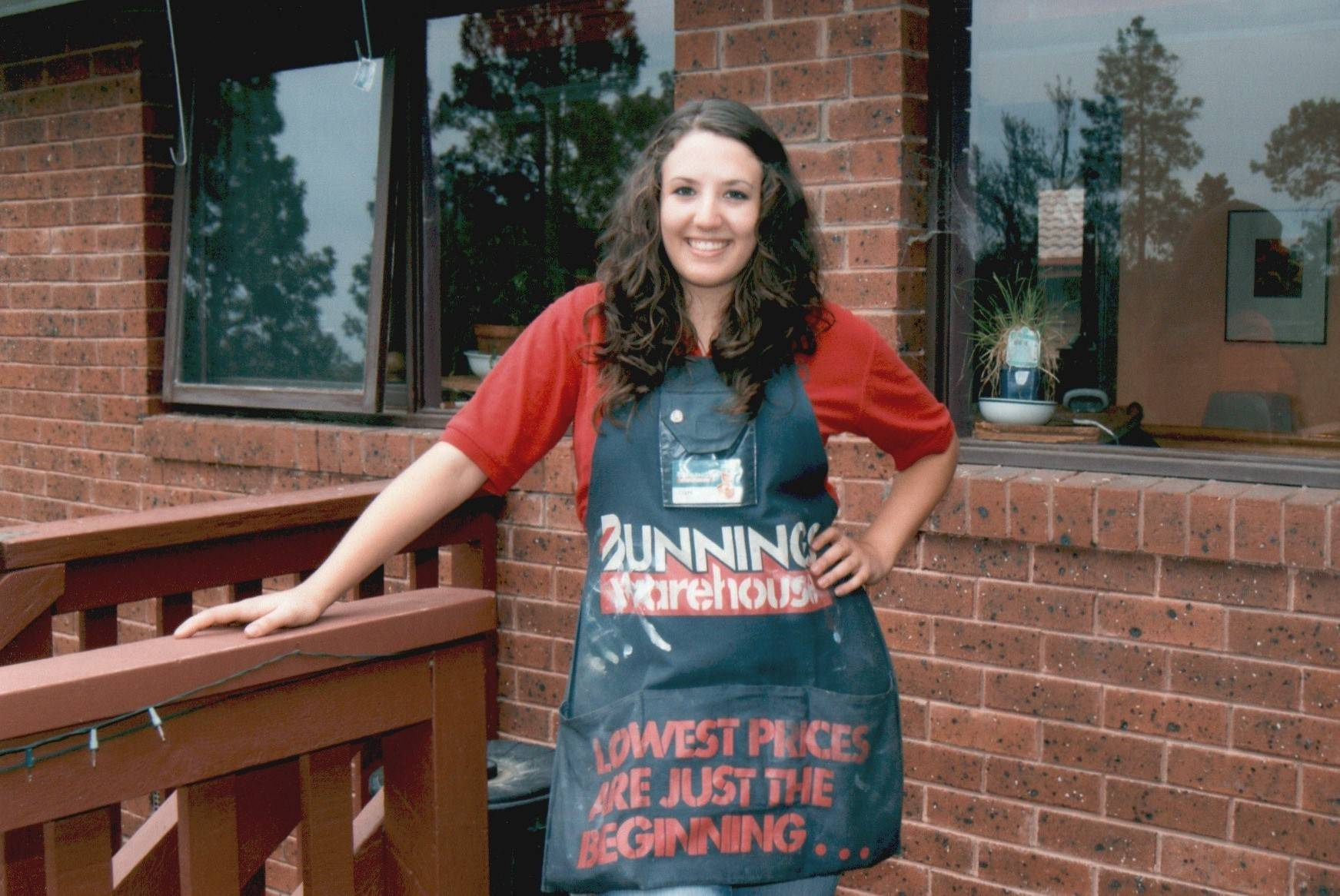 Caity in a Bunnings apron on the veranda