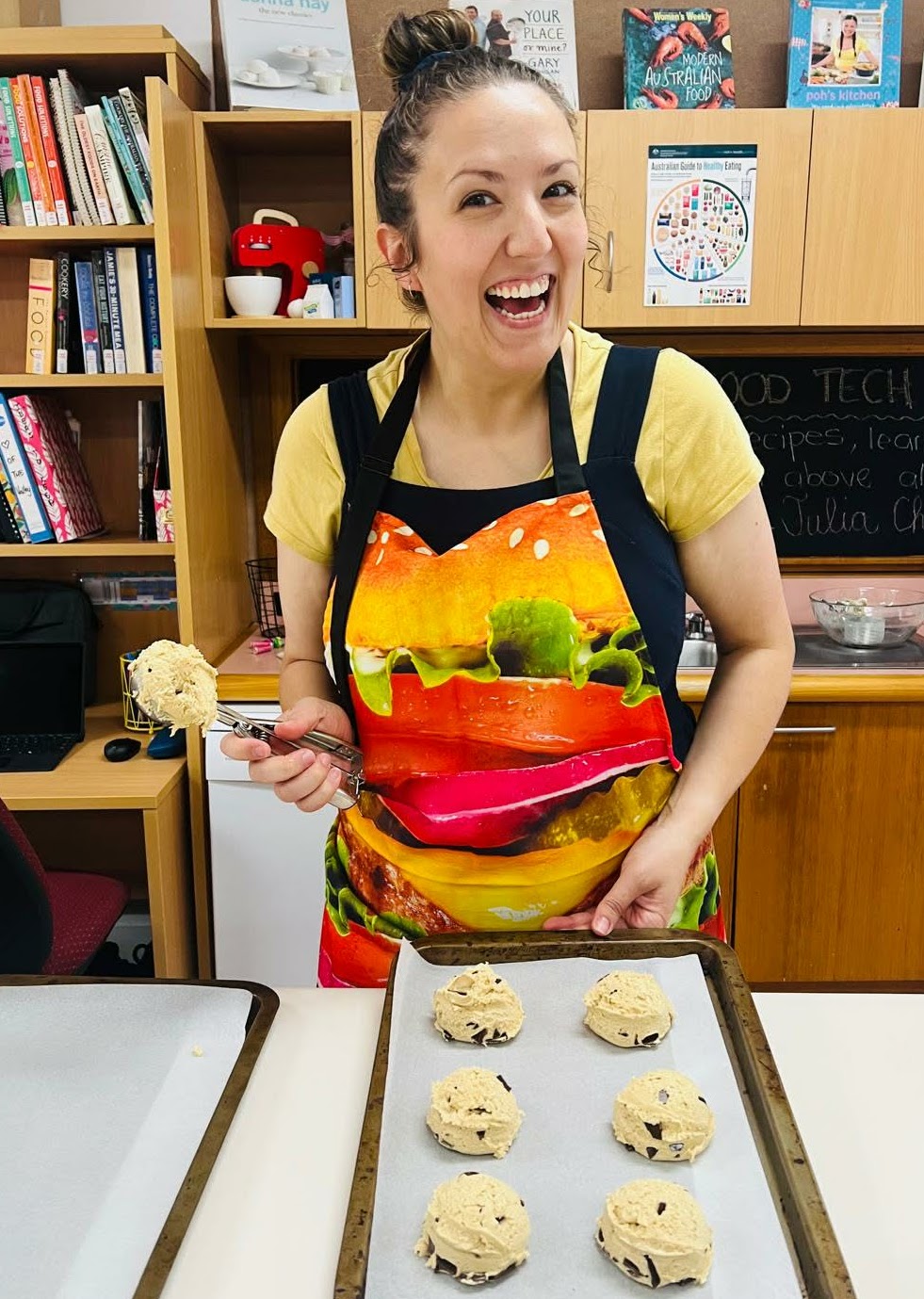Caity in a chef's apron in her Food Tech classroom